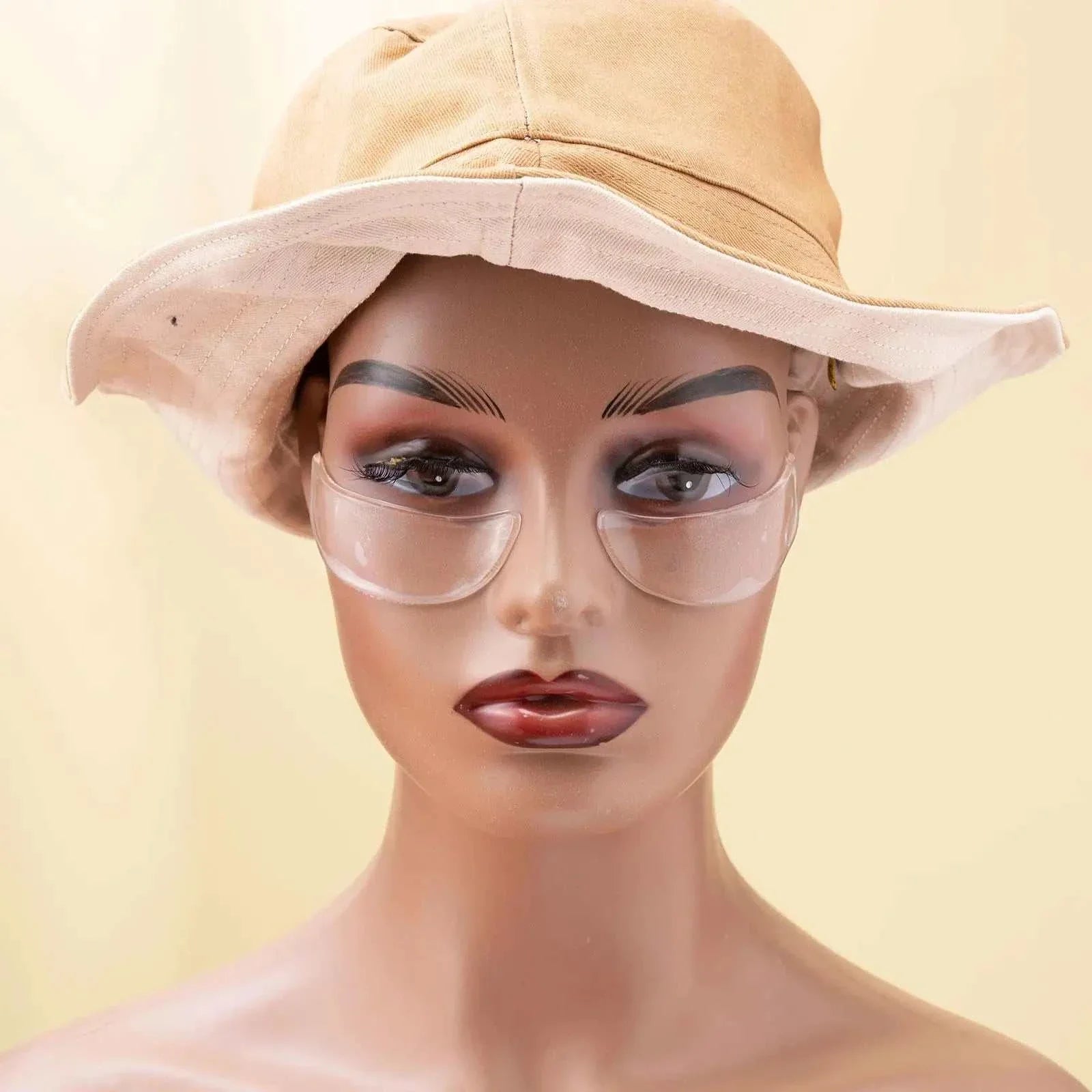 Mannequin wearing reusable anti-wrinkle silicone forehead and under-eye patches with a beige hat