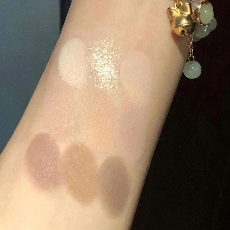 Swatches of Black Pink Smoky Eye shadow palette showing pearlescent and matte chocolate-inspired neutral shades on arm