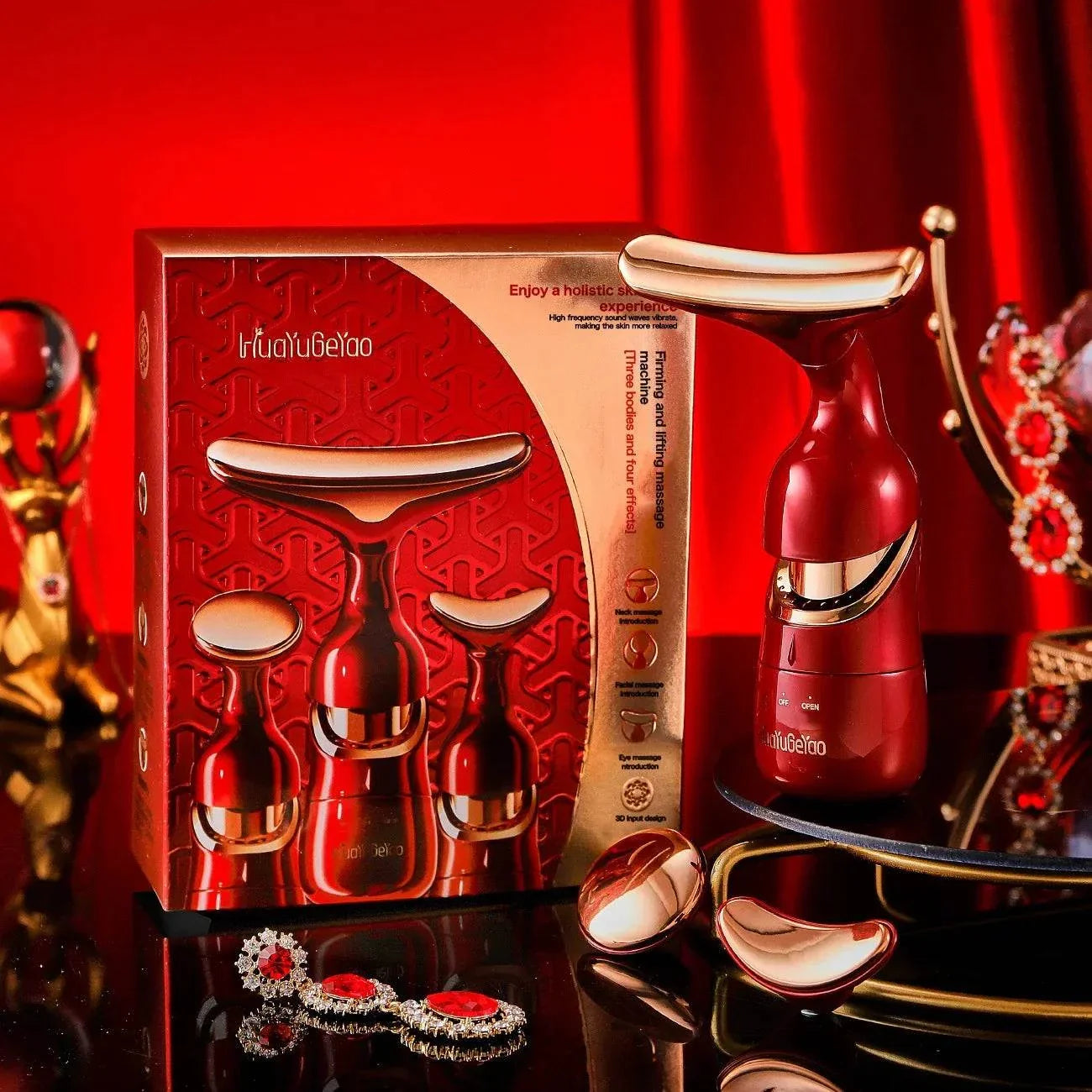 3-in-1 Facial Lifting Device in red and gold with neck, face, and eye massage attachments displayed with packaging and jewelry accessories