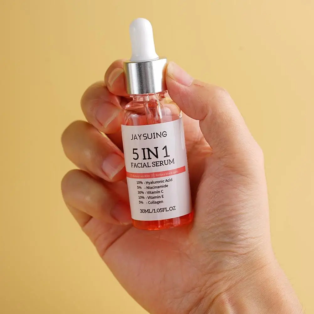 Hand holding 5 In 1 Fade fine lines firming face serum bottle with dropper against beige background