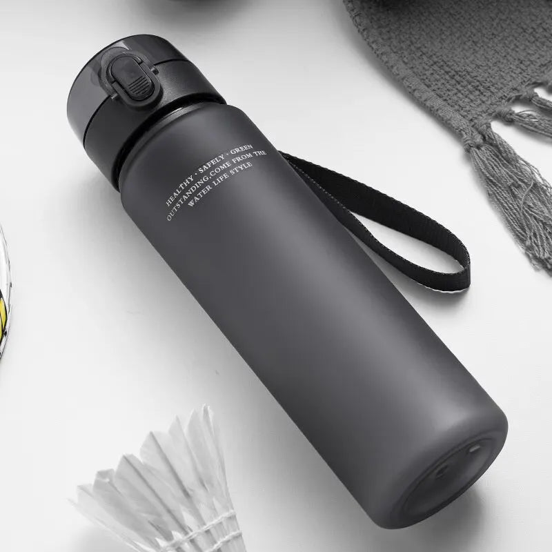 Black BPA-free leak-proof sports water bottle with carrying strap for hiking and fitness activities