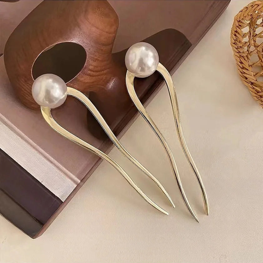 Pair of elegant pearl U-shaped hairpins with gold-toned metal, perfect for stylish hair buns and updos