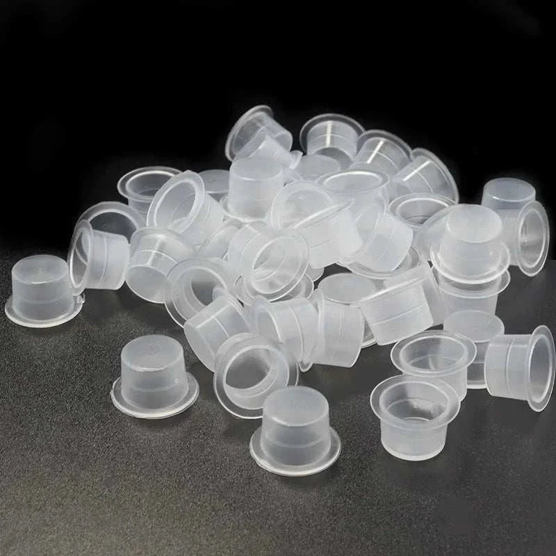 Clear disposable plastic ink cups in assorted sizes for tattoo and permanent makeup pigment holders, 100-pack.