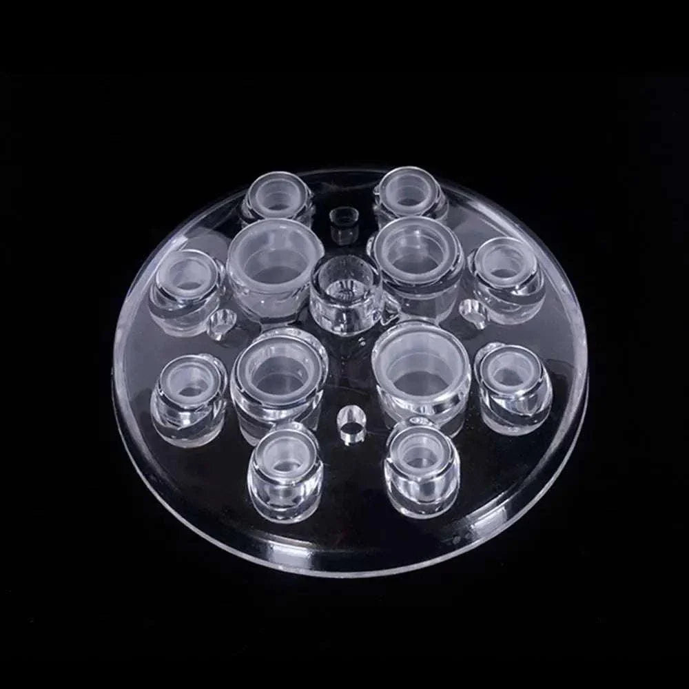 Set of clear disposable plastic ink cups in assorted sizes on a round tray for tattoo and permanent makeup use