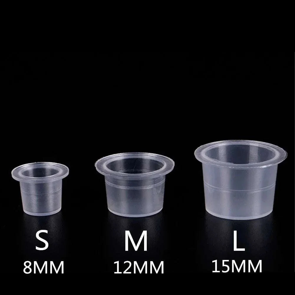 Set of three clear disposable plastic ink cups in small (8mm), medium (12mm), and large (15mm) sizes for tattoo and permanent makeup pigment use