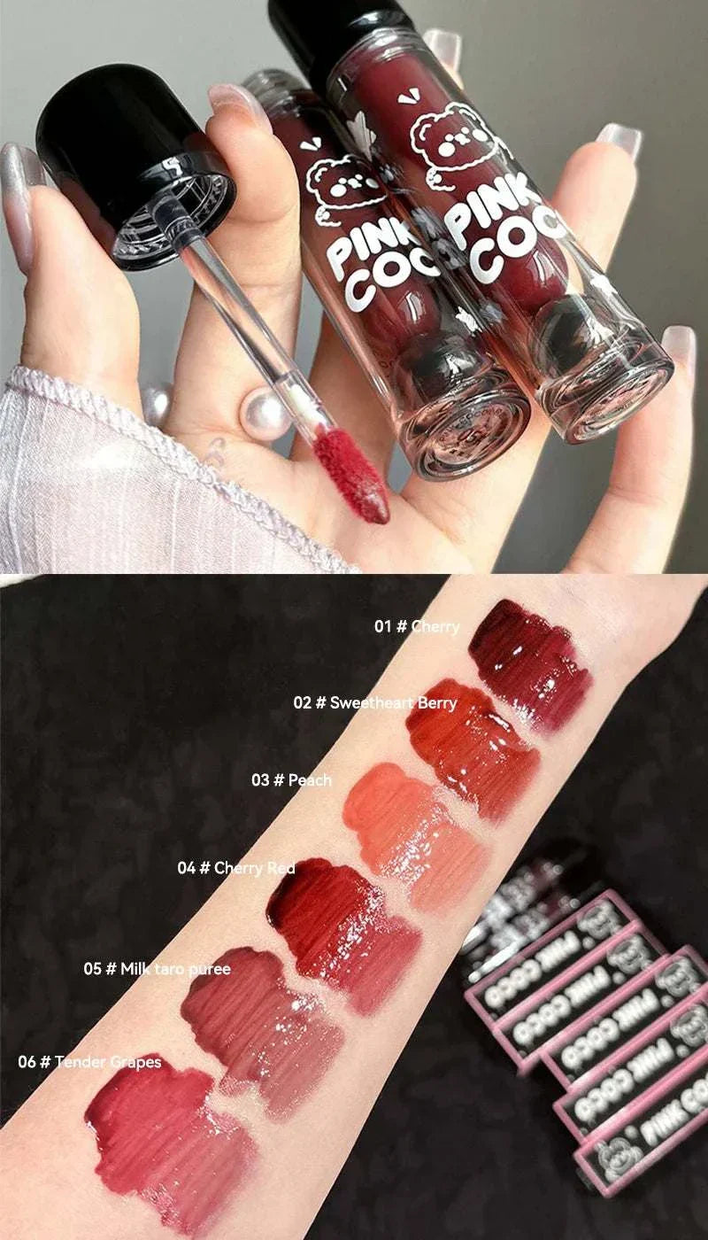 PINKCOCO Bear Doodle Mirror Lip Glaze tubes with applicator and six glossy lip glaze swatches on arm in various shades of red and pink