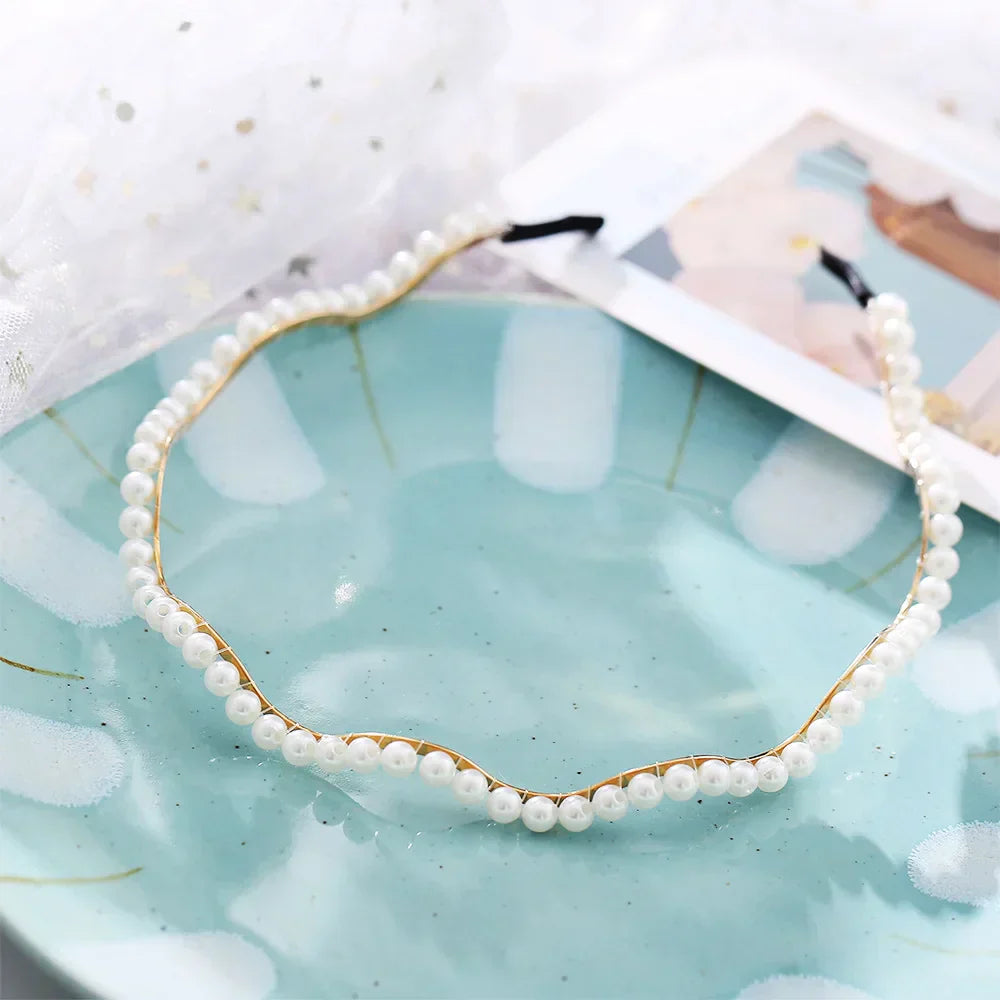 Modyle Full Pearl Hairband with floral design and elastic fit on turquoise plate