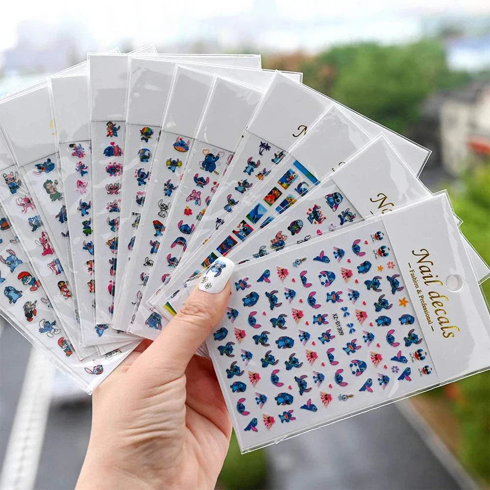 Hand holding multiple packs of Cartoon Mini Stitch angel nail stickers with various colorful designs for nail art.