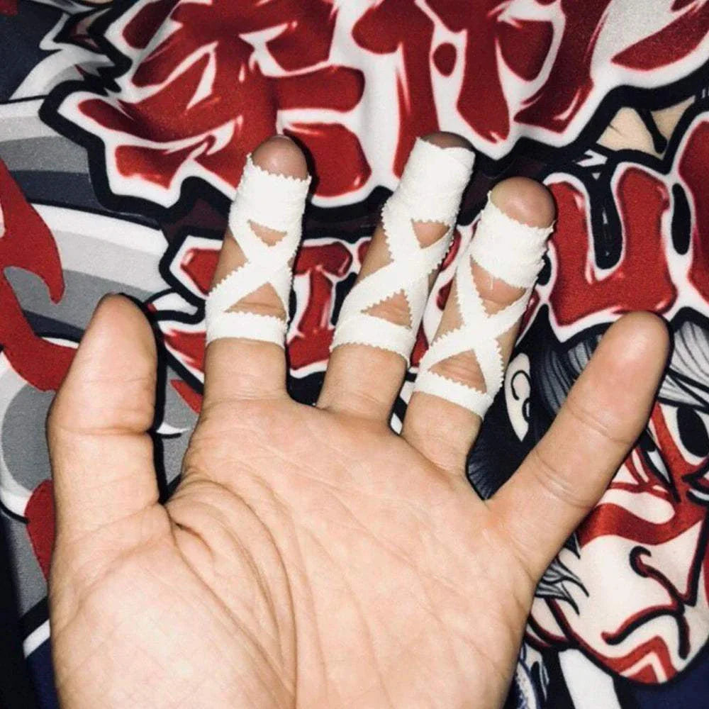 Hand with fingers wrapped in white Jiu-Jitsu elastic bandage tape for joint protection and grip support during martial arts training