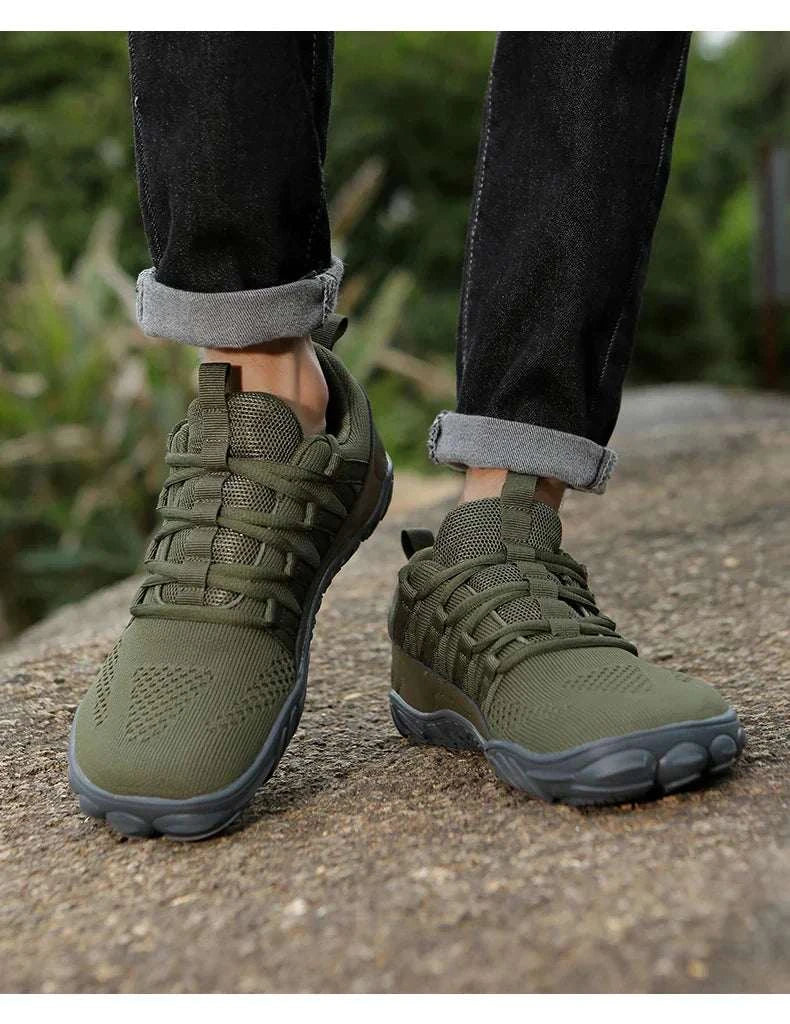 Green breathable new hiking shoes with lightweight flexible soles worn outdoors on trail