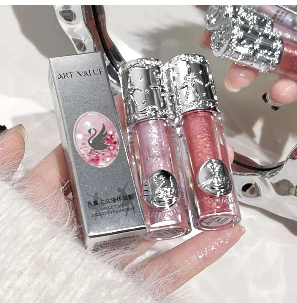 Close-up of Balletism Liquid Eyeshadow in delicate pink and coral shimmer shades with ornate silver caps and elegant packaging.