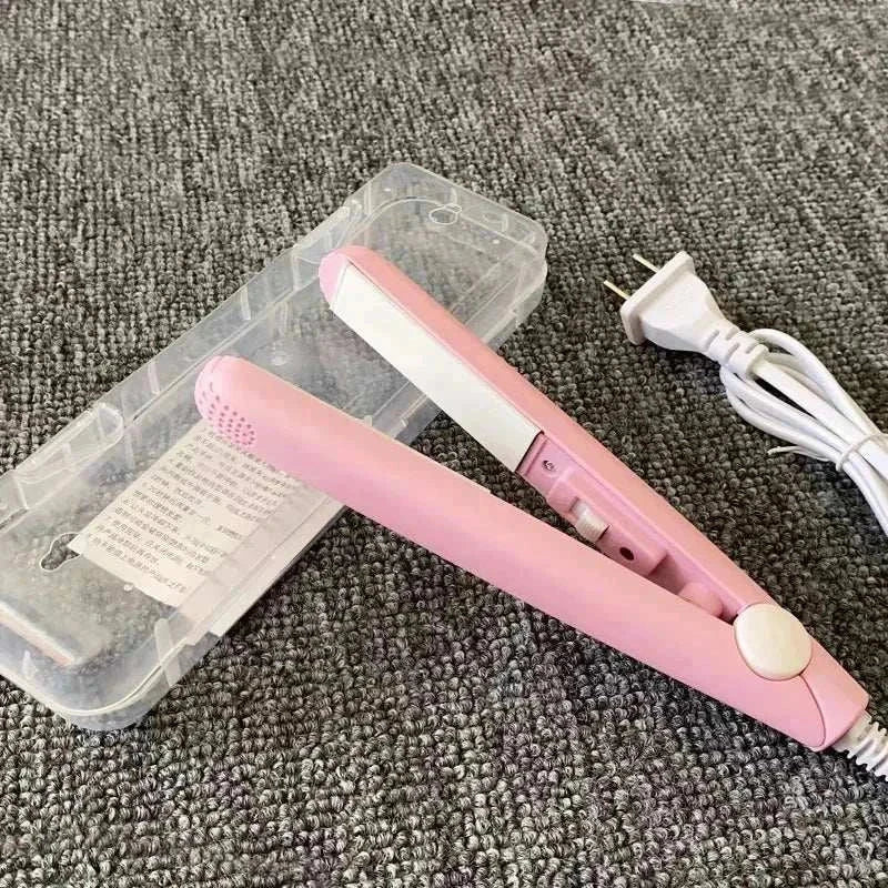 Compact pink mini flat iron for travel with protective case and power cord on gray surface