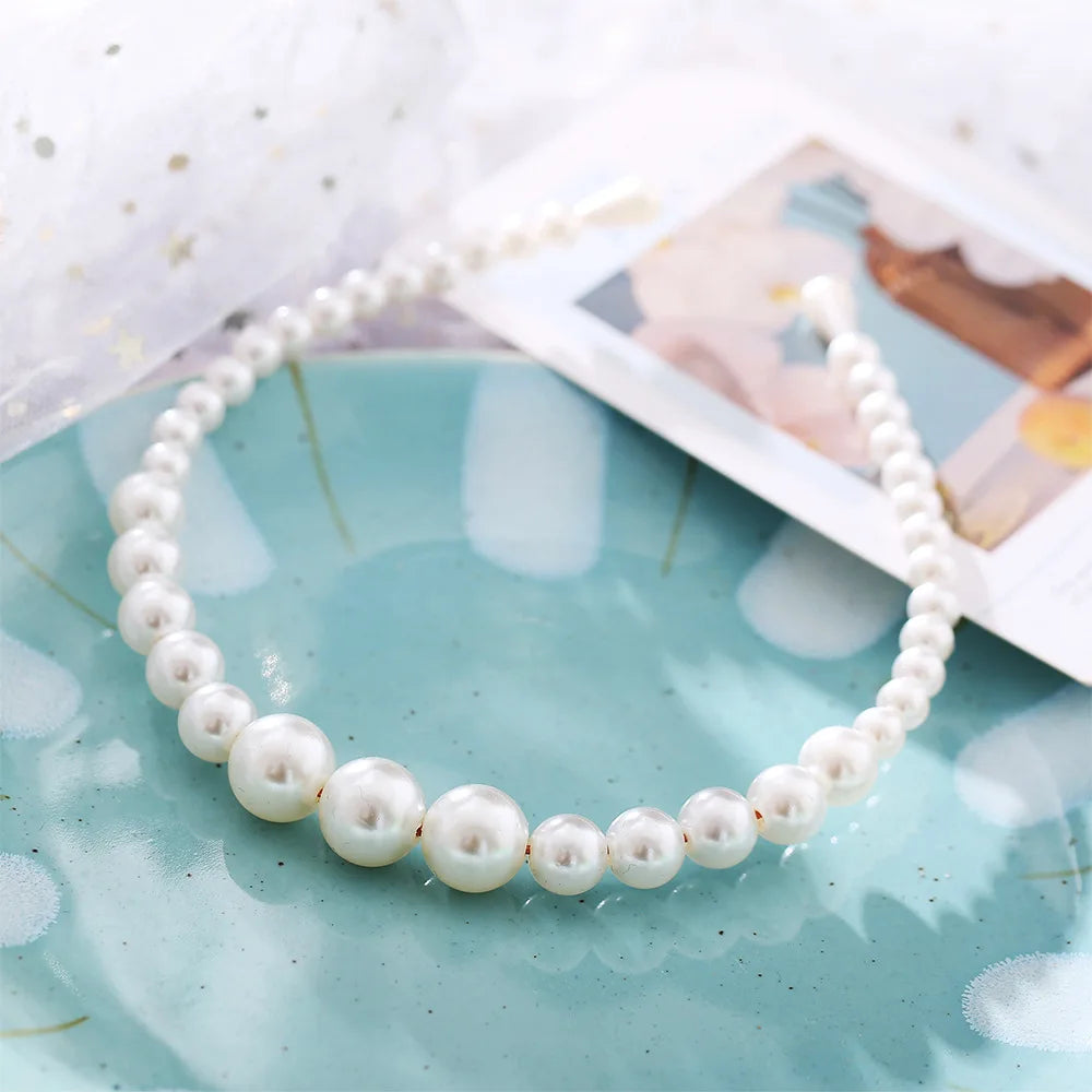 Modyle Full Pearl Hairband elegant floral elastic headband with glossy pearls on blue plate