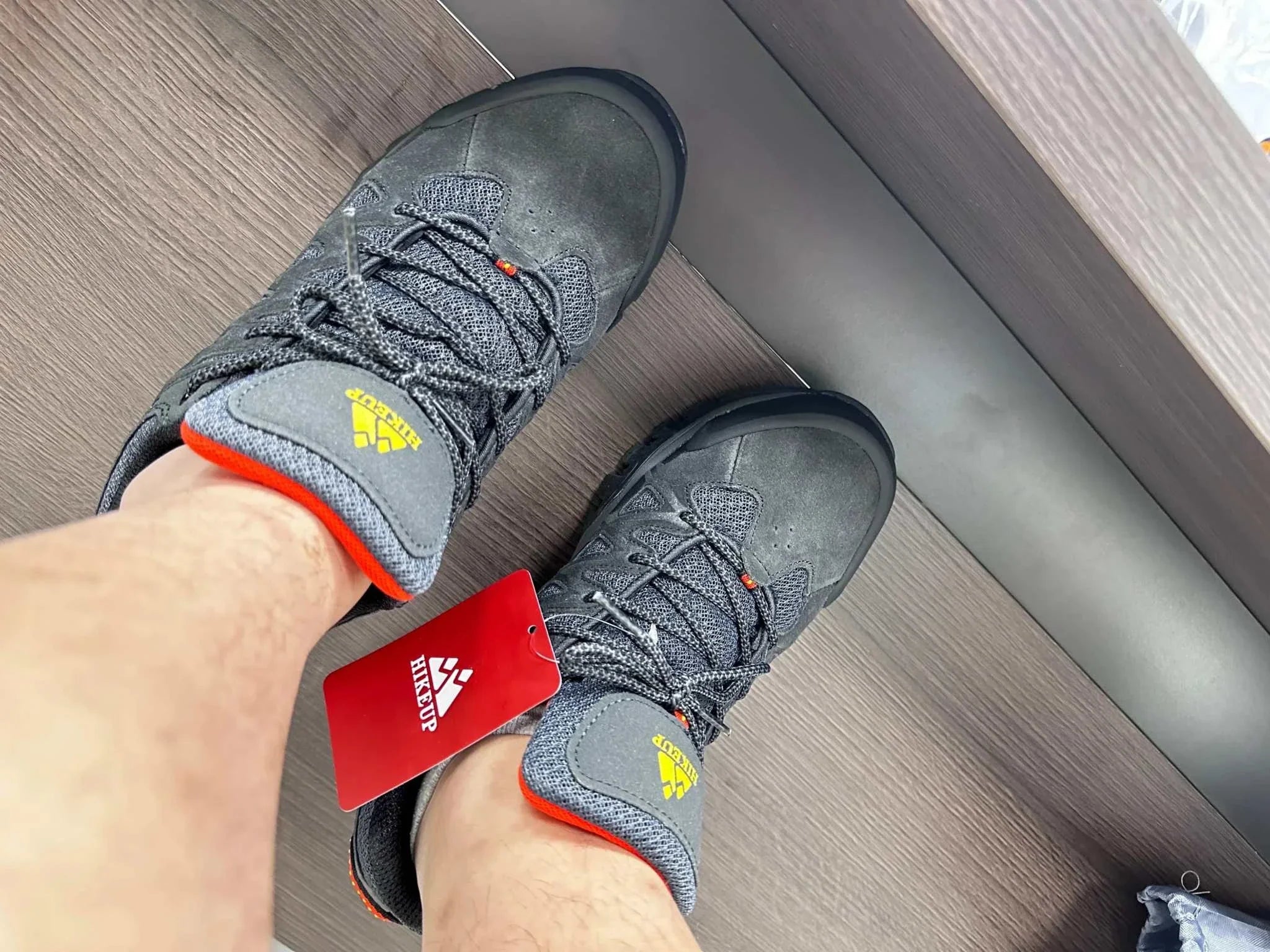 Men's Hiking Shoes by HIKEUP in grey and black with red accents, worn on feet, showcasing durable and stylish design for outdoor adventures.