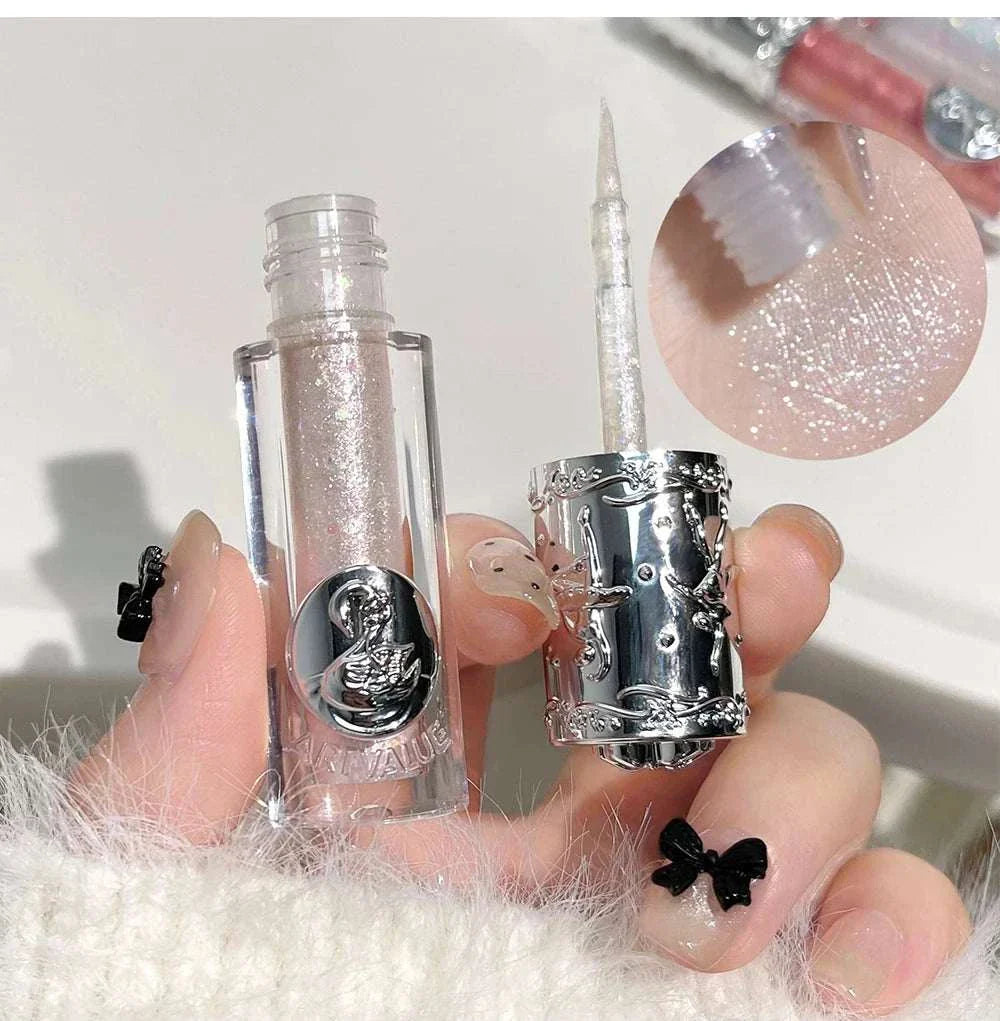 Balletism Liquid Eyeshadow with fine shimmer in elegant silver packaging, showing brush applicator and sparkly pale pink shade swatch.