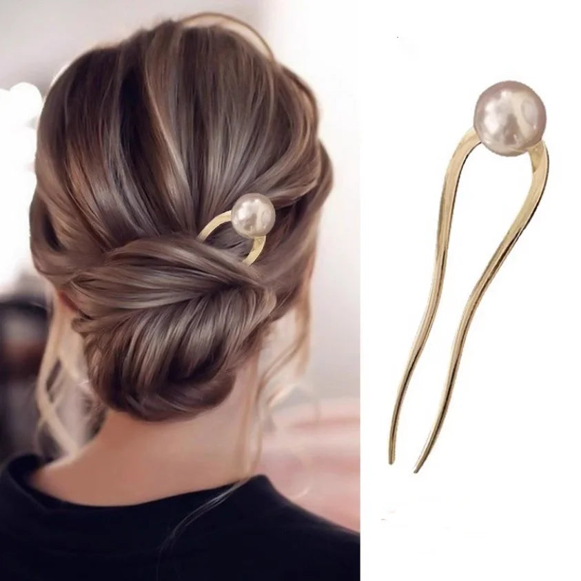 Elegant pearl U-shaped hairpin in gold metal securing a chic Korean-inspired bun hairstyle
