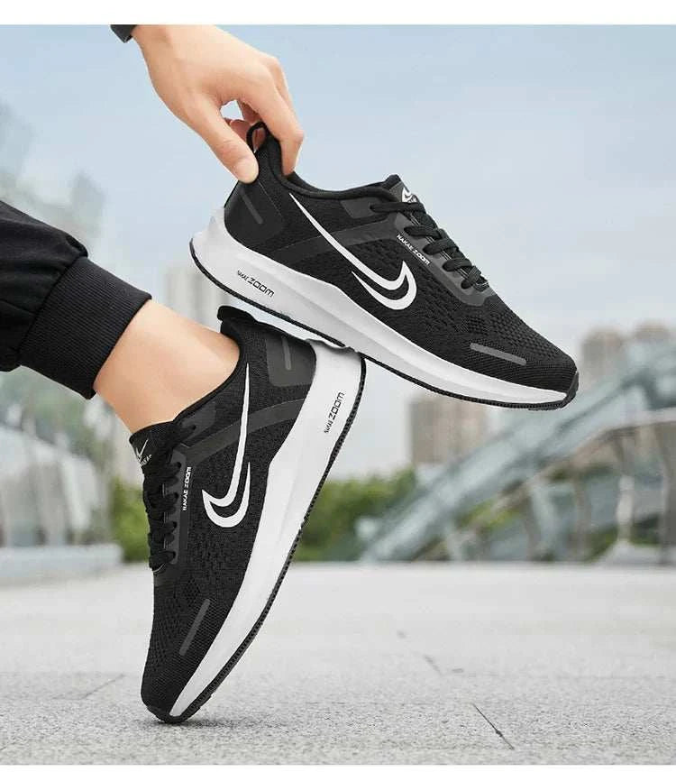 Black lightweight running shoes for men with breathable mesh and non-slip sole, shown outdoors on city pavement.