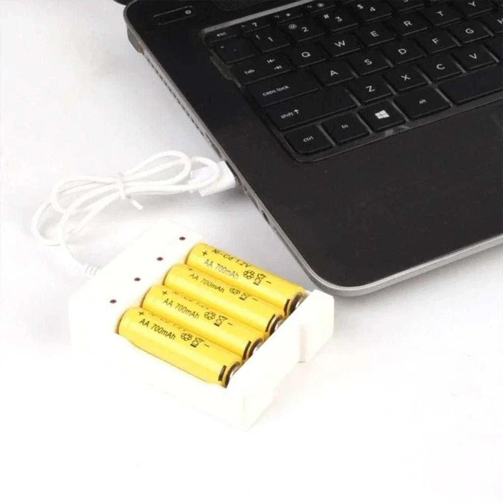 High-speed USB rechargeable battery charger with 4 slots connected to a laptop