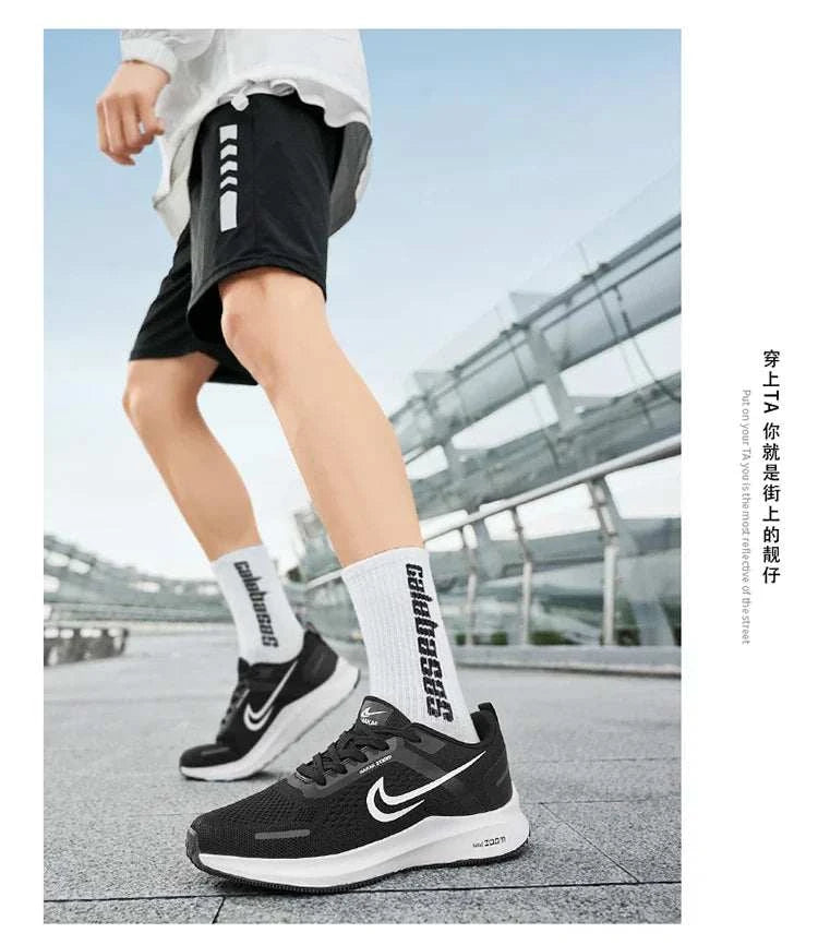 Men wearing black and white lightweight running shoes with breathable mesh and cushioned soles outdoors on a modern walkway.