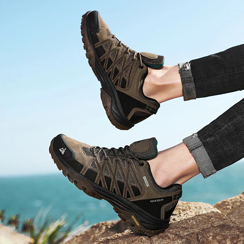 Men's hiking shoes with durable construction, superior grip, breathable design, and stylish all-terrain comfort against a coastal outdoor background