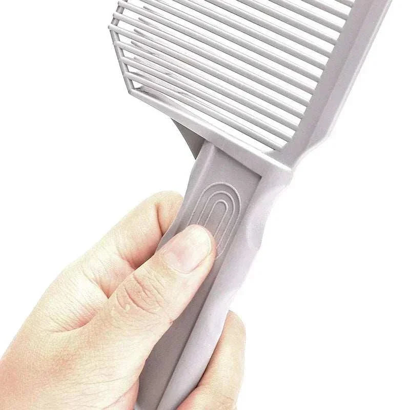 Hand holding gray barber fade comb with wide teeth and ergonomic grip for precision haircuts and fades