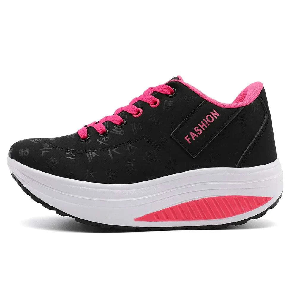 Black breathable wedge heel sneakers with pink laces and accents, thick cushioned sole, and lace-up closure for women