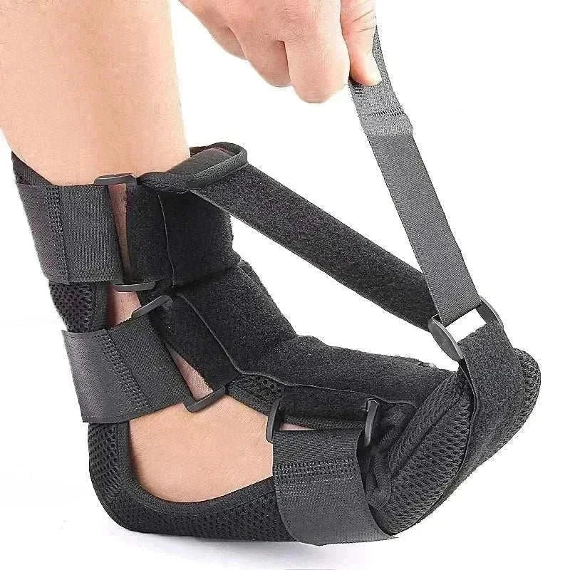 Black adjustable night splint for plantar fasciitis with breathable straps and cushioned sole.
