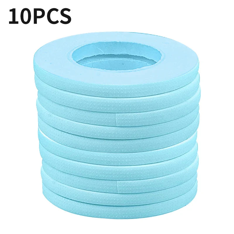 Stack of 10 blue micropore eyelash extension tapes for secure, gentle lash application