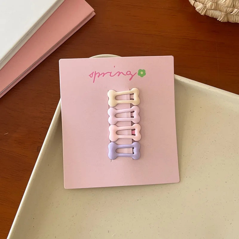 Set of 4 cute pastel geometric mini hair clips for kids on pink card