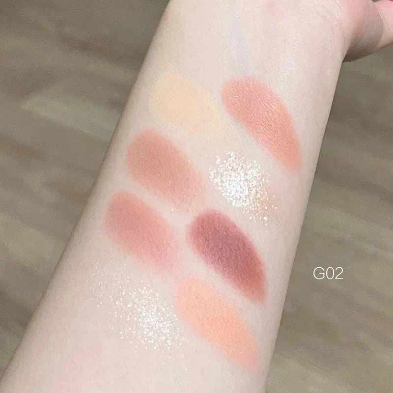 Swatches of 8-color pink orange eyeshadow palette on arm showing matte and shimmery peach, coral, and pink shades.