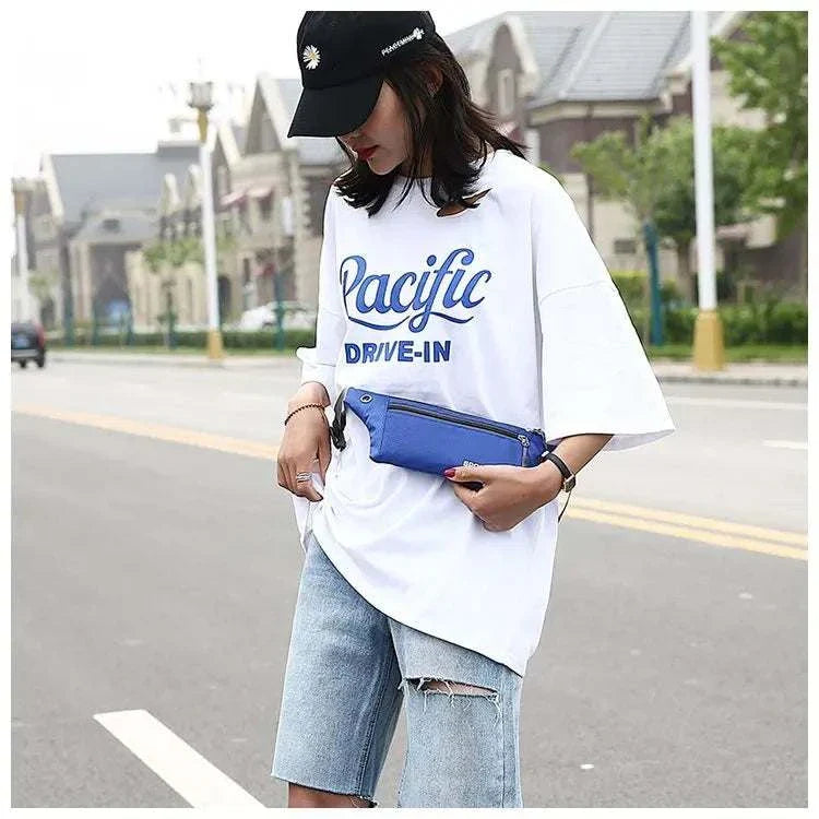 Woman wearing casual blue nylon waist and chest bag with adjustable strap outdoors