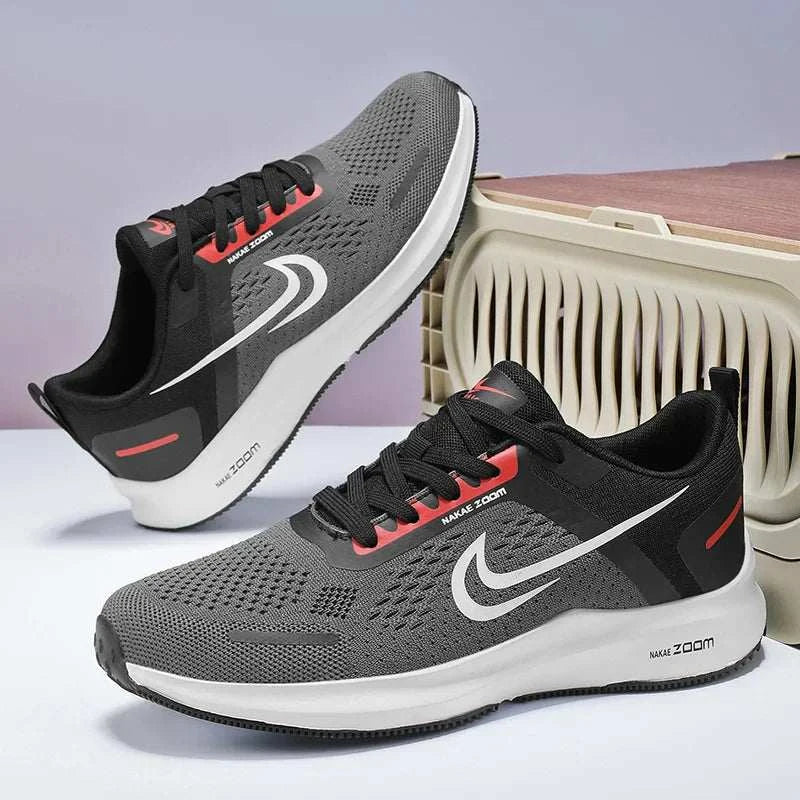 Men's lightweight running shoes in grey with black and red accents, breathable mesh upper, cushioned sole, and non-slip rubber outsole for athletic performance.