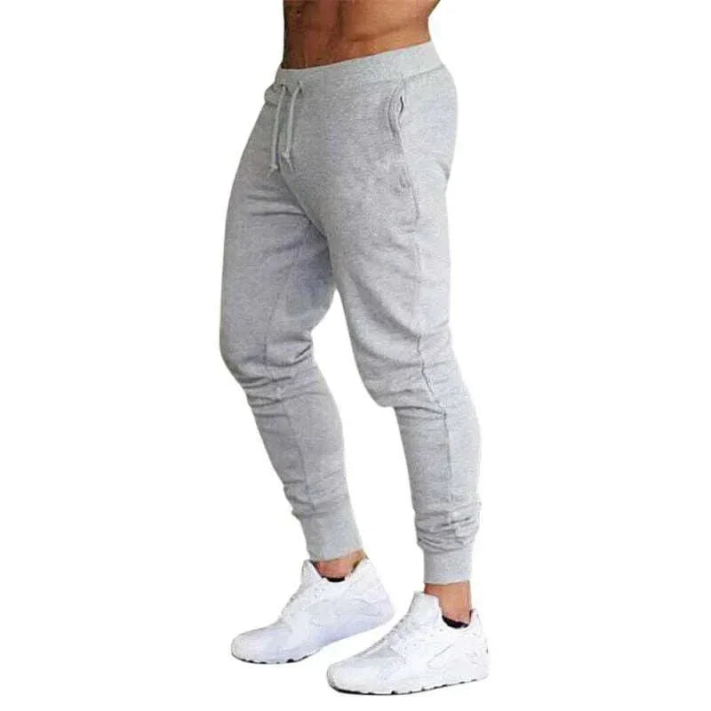 Gray men's training jogger sweatpants with tapered fit, elastic waistband, and drawstring.