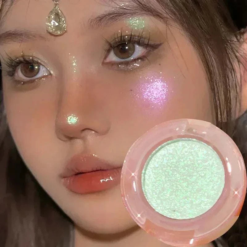 Close-up of a woman with diamond glitter monochrome eyeshadow highlighting her cheeks, eyelids, and nose, holding a shimmery pale green eyeshadow pot from the Diamond Glitter Monochrome Eyeshadow Palette.