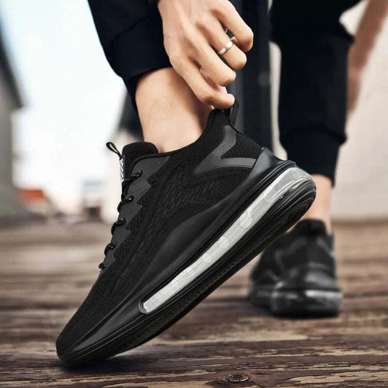 Black breathable unisex sneaker with mesh upper and cushioned sole for walking and running.