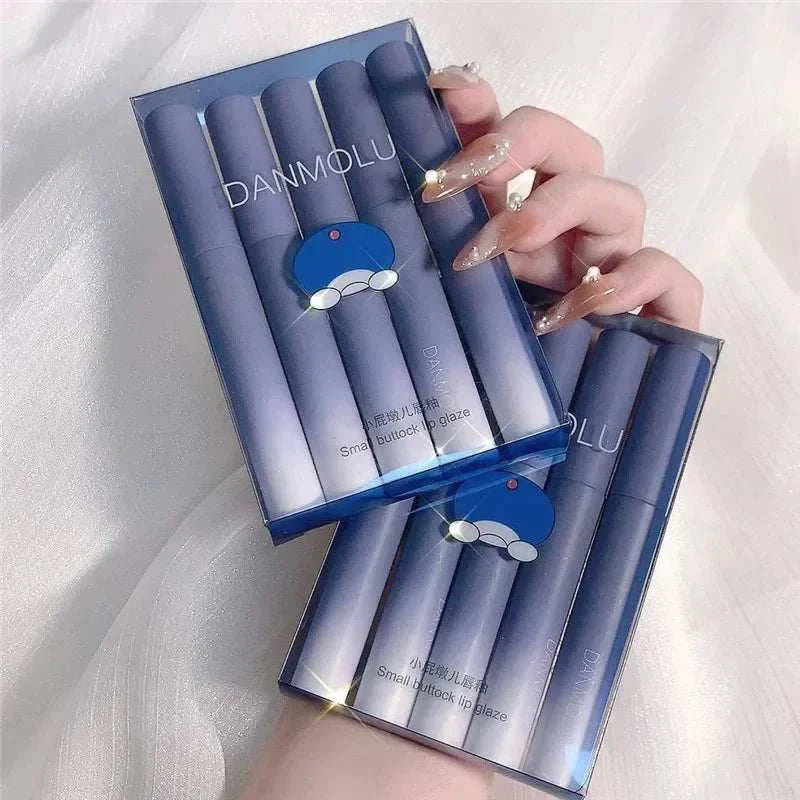 Blue-themed matte lipstick set with five shades in sleek packaging held by hand with decorated nails
