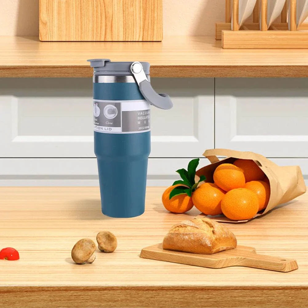 30oz stainless steel vacuum insulated cup with handle and leak-resistant lid on kitchen counter next to bread and oranges