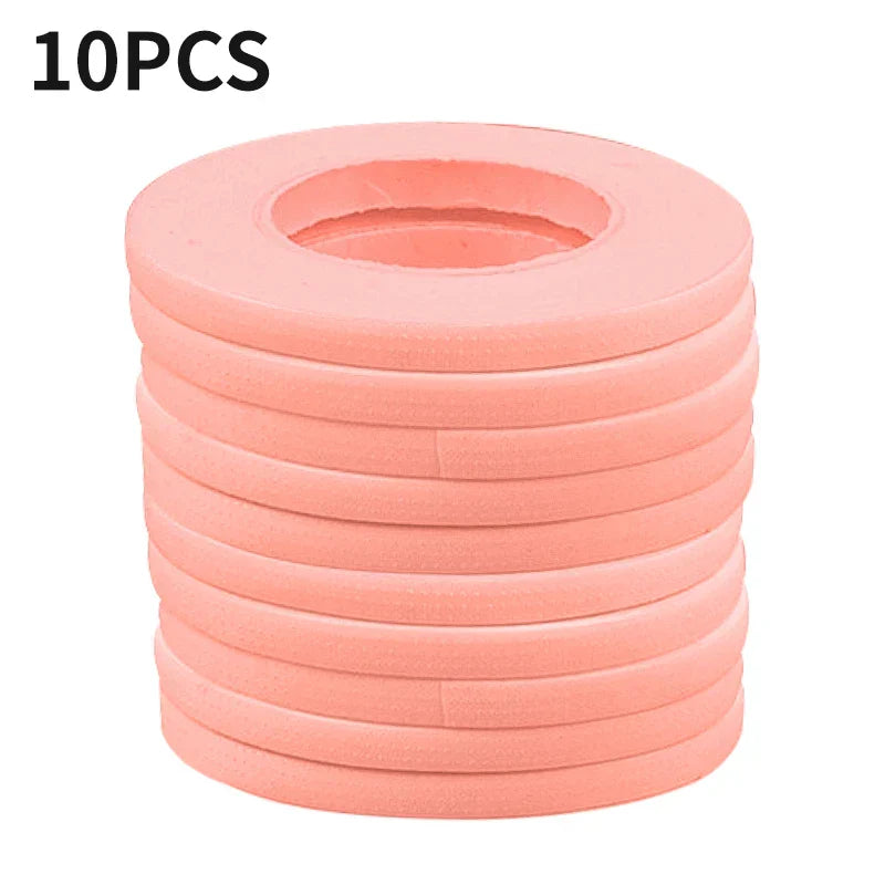 Stack of 10 rolls of pink micropore eyelash extension tape for gentle and precise lash application