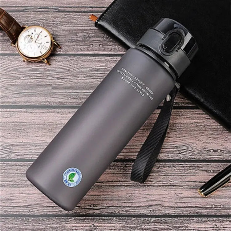 BPA-free leak-proof black sports water bottle with secure lid and strap on wooden surface