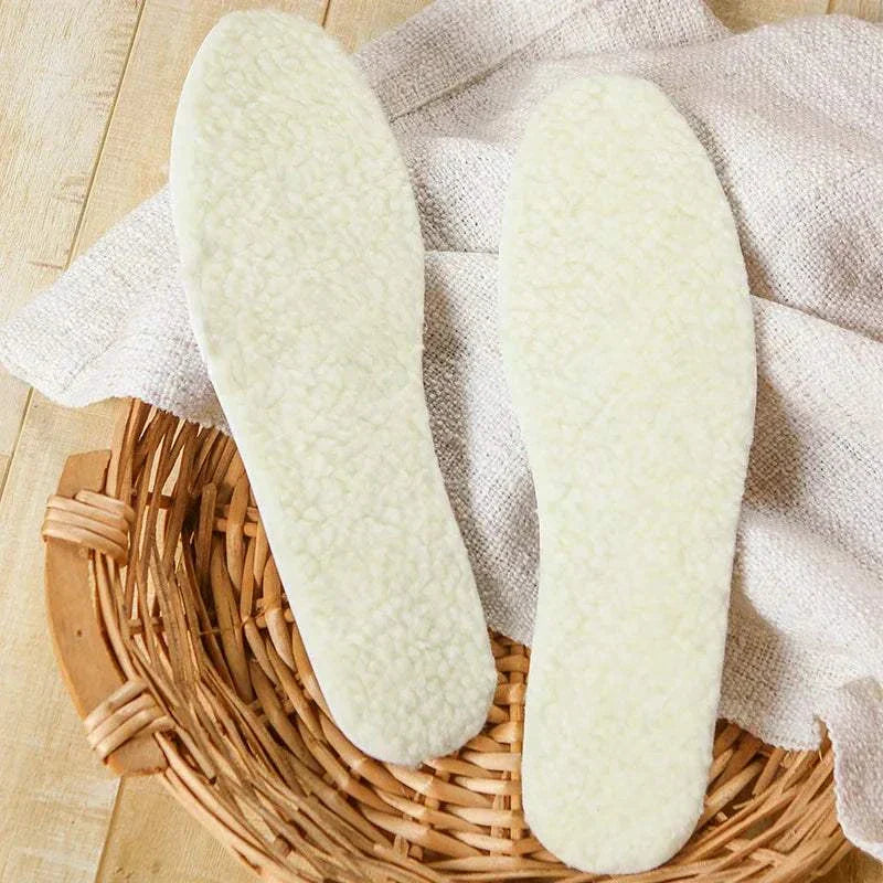 Pair of natural lamb fleece insoles on a wicker basket with a cozy textile background