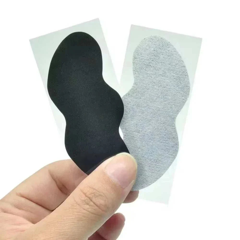 Hand holding black and gray facial blackhead removal stickers for deep pore cleansing and skin care