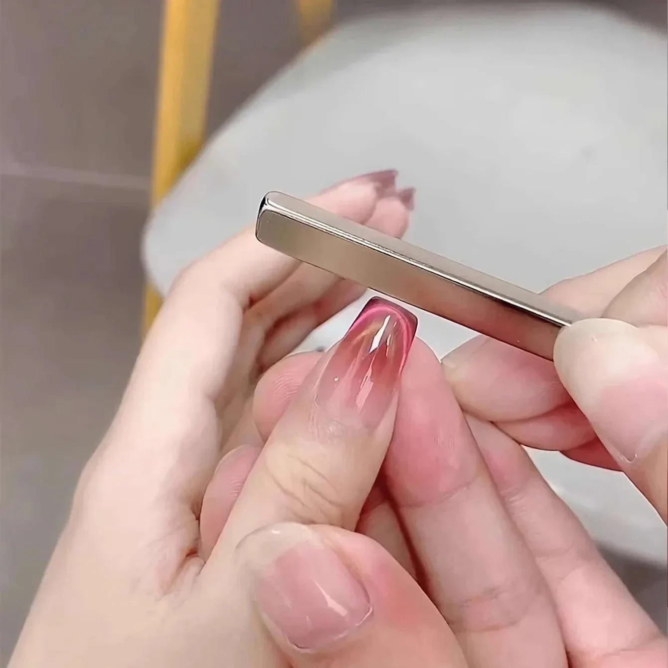 Nail Art Magnetic Pen creating 3D cat eye effect on gel polish nails with dual-ended magnet wand for precise nail designs.