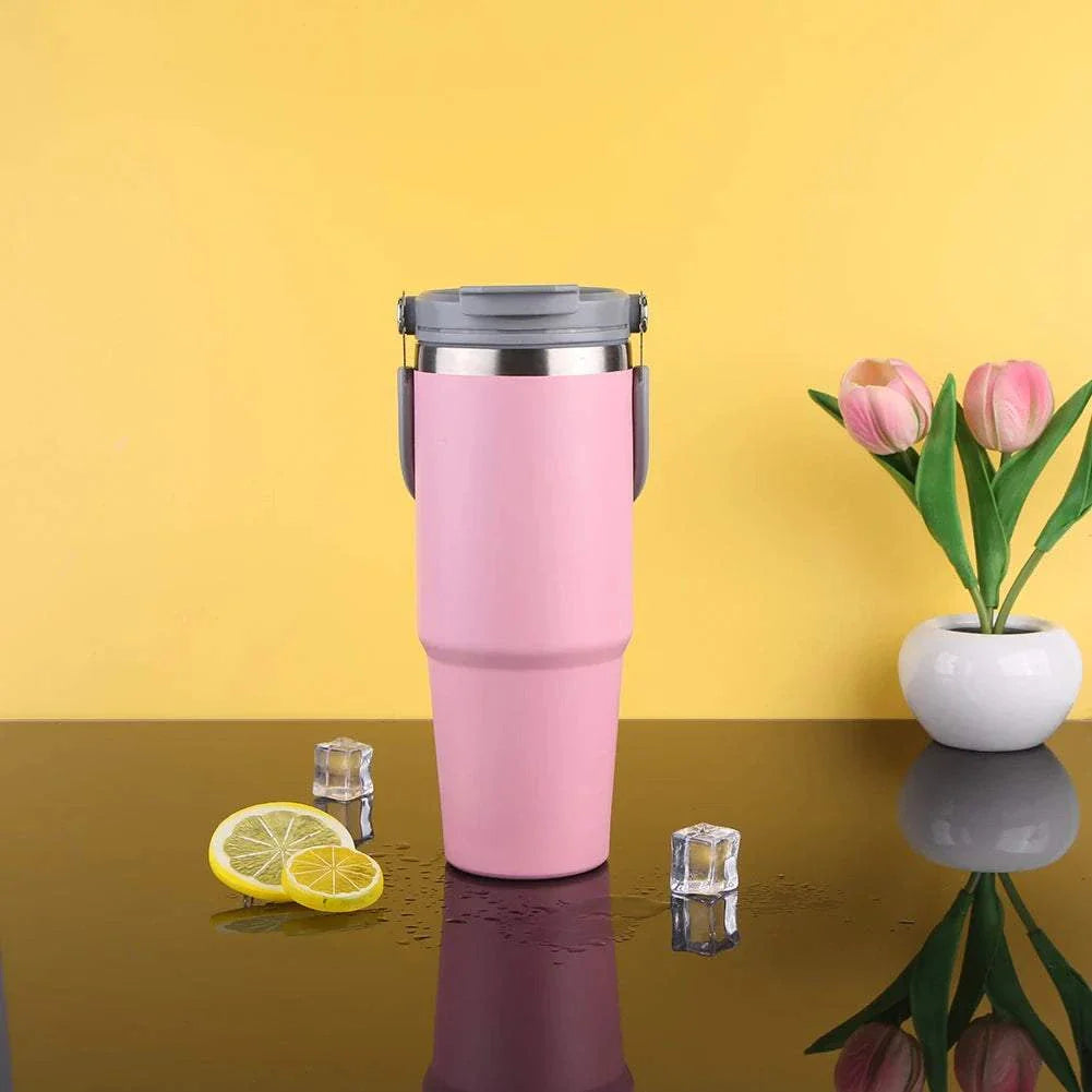Pink 30oz vacuum insulated cup with handle, stainless steel double-layer, on reflective surface with ice cubes and lemon slices, yellow background