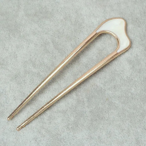 Pearl U-shaped hairpin with metallic shell design on gray background for elegant bun styling