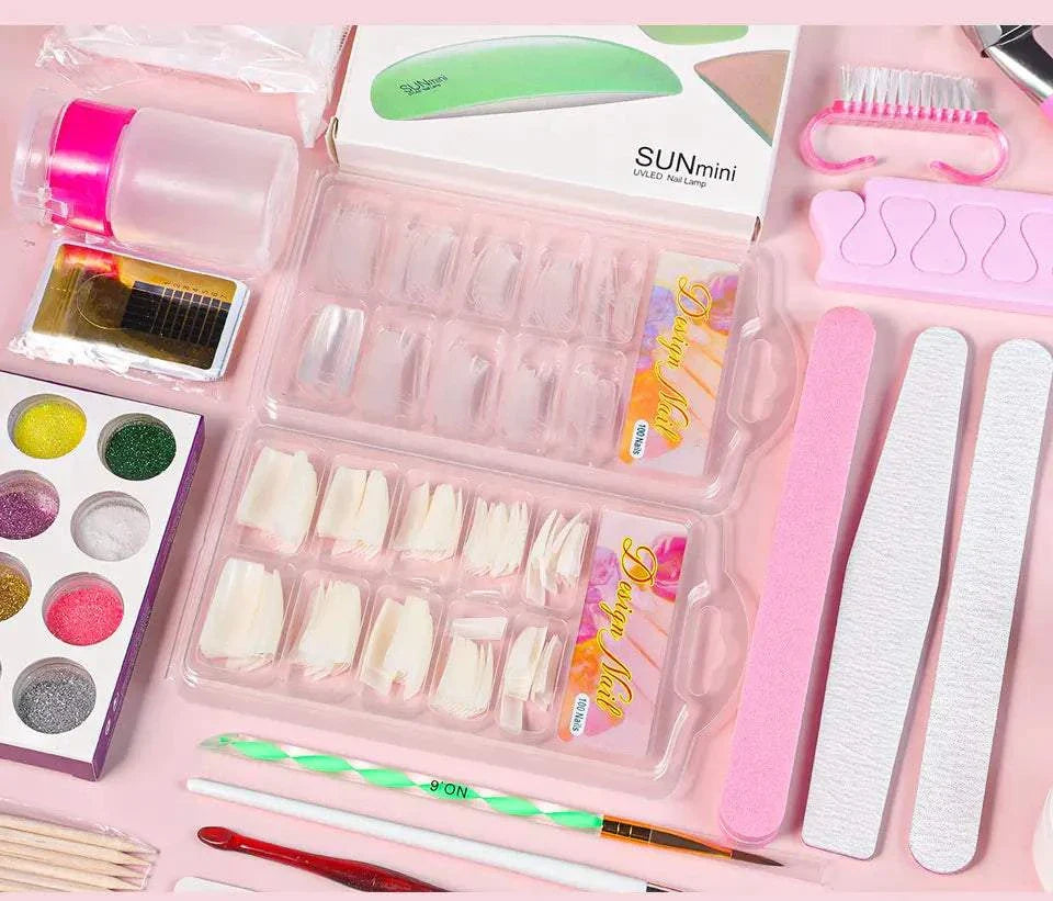 Nail acrylic powder and liquid monomer kit with nail tips, nail files, glitter powders, brushes, and nail tools on pink background