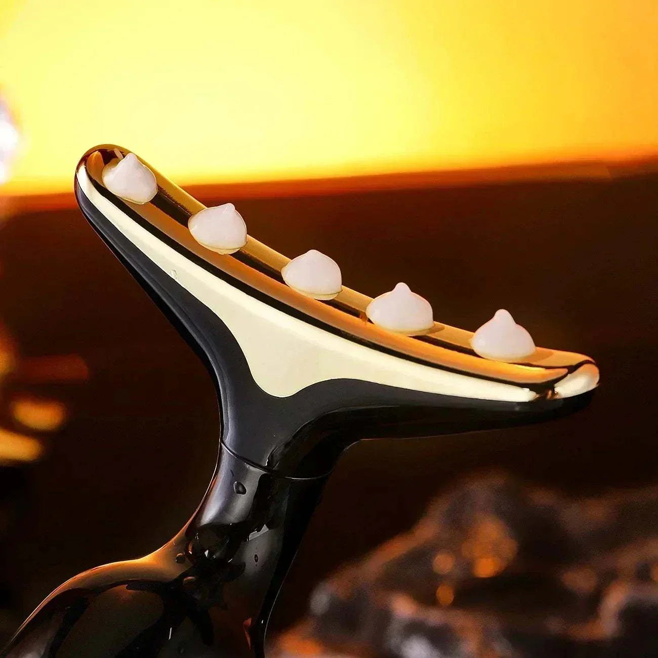 3-in-1 Facial Lifting Device with curved design and skincare cream dots for neck, face, and eye massage and firming