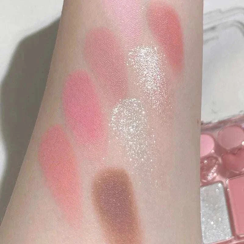 Swatches of 8-color pink orange eyeshadow palette showing blendable pink, orange, peach, and shimmery shades on skin.