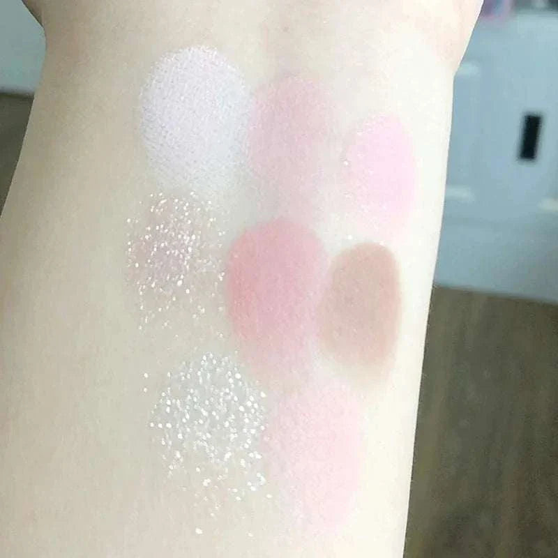 Swatches of 8-color pink orange eyeshadow palette showcasing various pink, peach, and shimmery shades on fair skin.
