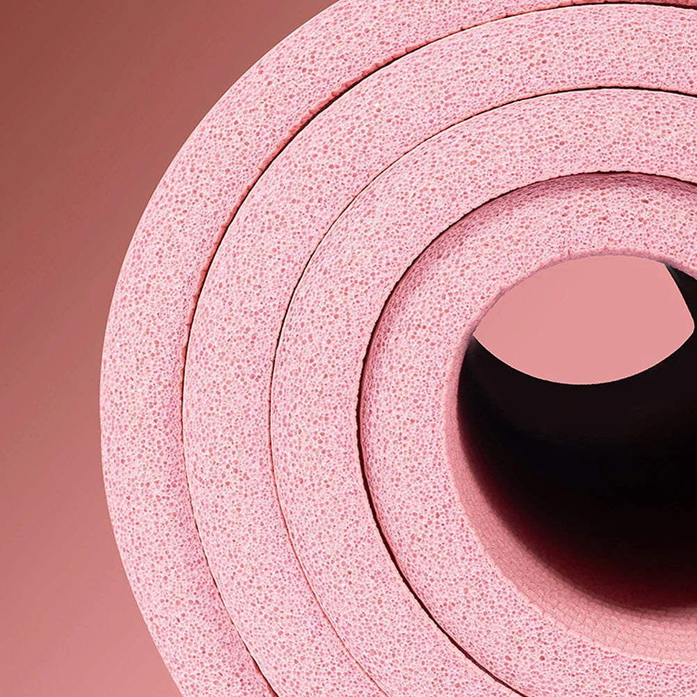 rolled pink non-slip yoga mat with textured surface for grip and cushioning