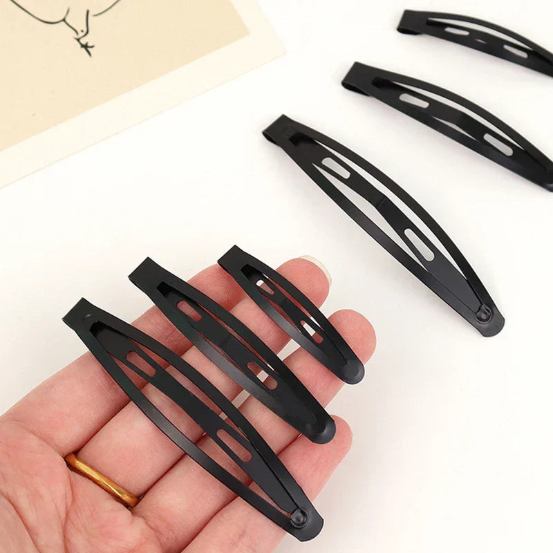 10 black frosted alloy snap hair clips with matte finish held in hand for secure and stylish hold